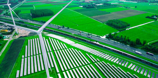 Aerial view taken with drone flying above the highway with the green landscape of the Netherlands, wind turbines and solar panel farm. Netherlands.